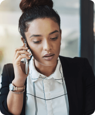 A smiling woman looking at her laptop wearing headphones