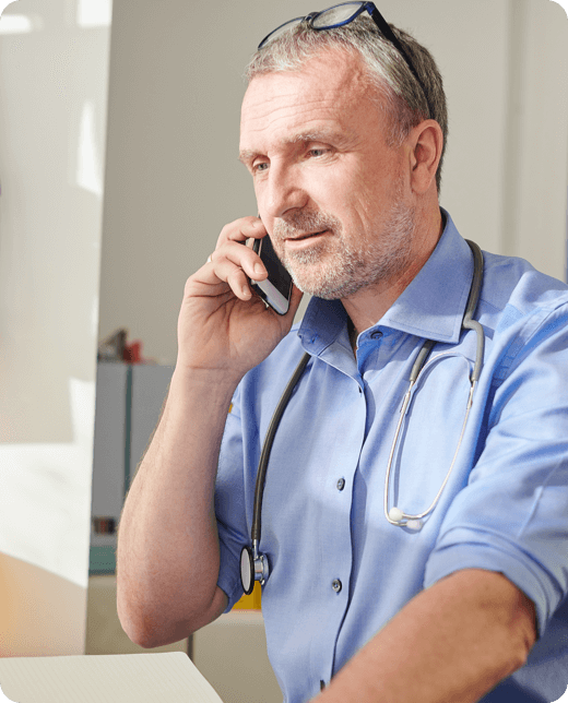 A smiling man in blue shirt looking at his phone