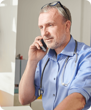 A smiling man in blue shirt looking at his phone
