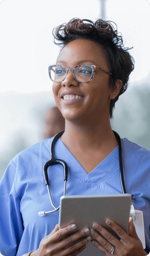 A smiling woman looking at her laptop wearing headphones